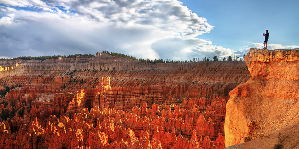 Man standing on a ledge overlooking Bryce Canyon National Park