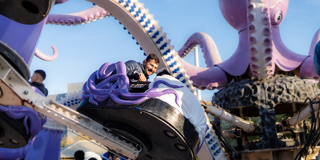 Man smiling while in a purple octopus ride